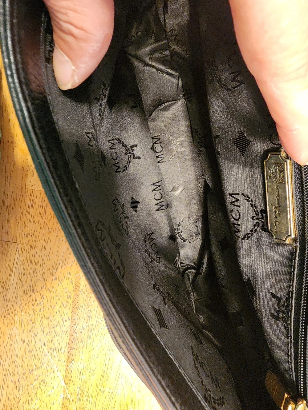 vintage MCM black pebbled leather studded crossbody bag featuring a front plaque